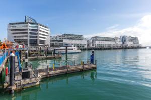 a dock with a boat in the water next to buildings at *Vibrant Viaduct Harbour Apartment with Balcony & Best Location* Auckland in Auckland