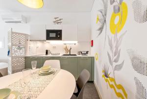 a kitchen and dining room with a table and chairs at Casa do Sapalinho I - Setubal Downtown in Setúbal +5 photos