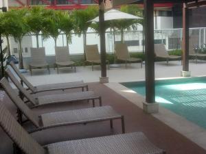 a courtyard with chairs and a pool in a building at Aparthotel Condomínio Mondial in Salvador