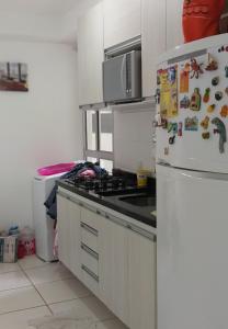 a kitchen with a refrigerator with magnets on it at Condomínio Conquista Premium Aleixo in Manaus