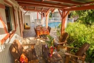 a patio with a table and chairs and a pool at Les jardins de Pointe Noire in Pointe-Noire