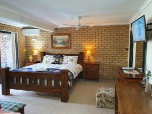 sypialnia z łóżkiem i ceglaną ścianą w obiekcie Gowrie Agapanthus w mieście Singleton