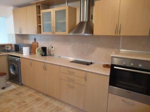 a kitchen with wooden cabinets and a stove at Villa Visoka in Balchik +11 photos