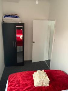 a bedroom with a red bed and a mirror at Watford Town centre Apartment in Watford