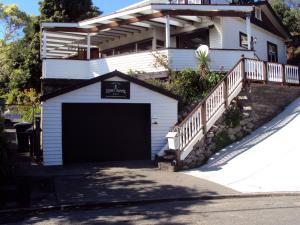 a white house with a garage in front of it at Bluff Hill Lighthouse B&B in Napier