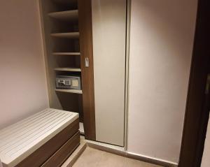 Zimmer mit einem Schrank mit einer Bank und einem Kühlschrank in der Unterkunft Grand Hotel Central Conakry in Conakry
