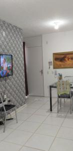 a living room with a table and a tv on a wall at Condomínio Conquista Premium Aleixo in Manaus