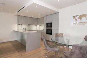 a kitchen with a glass table and chairs at LUXURY 2Bed & 2Bath Apartment Next to London Museum in The Hyde