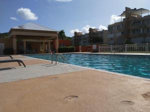 a swimming pool in front of a building at Coastal View Apartment in Ceiba