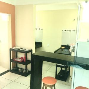 a bathroom with a black counter and two mirrors at Suites e Flats Trancoso in Trancoso