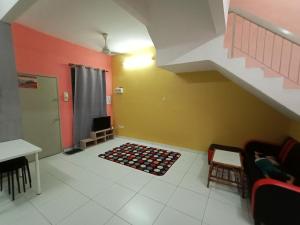 sala de estar con escalera y alfombra en Kak Chik Muslim Homestay en Kepala Batas