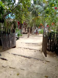 une clôture sur la plage avec des arbres et une maison dans l'établissement Maria Teresa Bragança Pousada, à Jericoacoara