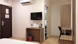 a hotel room with a bed and a tv on the wall at Tumike Hotel Bentong in Bentong