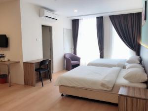 a hotel room with a bed and a desk and a desk at Tumike Hotel Bentong in Bentong