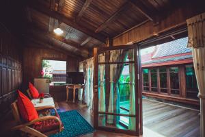 a room with a door open to a room with a balcony at Sasitara Thai Villas in Choeng Mon Beach