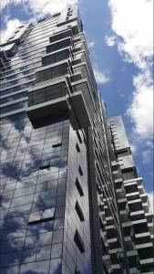 een hoog gebouw met een weerspiegeling van de hemel bij Cozy Studio 10min to KLCC next to Hospital Gleneagle Jalan Ampang in Kuala Lumpur