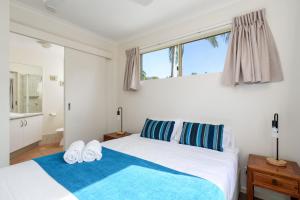 1 dormitorio con 2 camas y ventana en Rainbow Getaway Holiday Apartments en Rainbow Beach