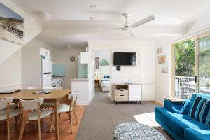 ein Wohnzimmer mit einem blauen Sofa und einem Tisch in der Unterkunft Rainbow Getaway Holiday Apartments in Rainbow Beach