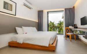 a bedroom with a bed and a large window at Saint Simeon Beach Residence in Long Hai