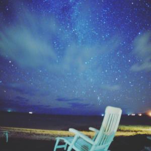 two chairs sitting on the beach under the stars at ALOALO BEACH 川平 in Fukai