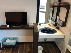 a bathroom with a sink and a large mirror at ビジネスインホテルプラザ21大阪京橋 in Osaka