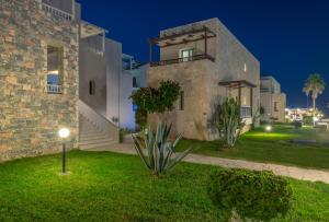 duży kamienny dom z ogródkiem w nocy w obiekcie Erato Hotel Adults Only by Smile Hotels w mieście Platanias