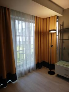 a room with a window with curtains and a lamp at Art Academy Apartment in Tallinn