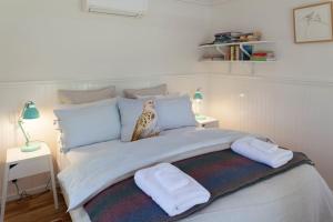 a bedroom with a large bed with two towels on it at Bird House in Kyneton