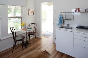a kitchen with a table and chairs and a sink at Bird House in Kyneton