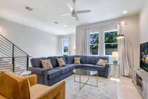 un salon avec un canapé bleu et une télévision dans l'établissement Bienville Villas: Brand New 4BR, à La Nouvelle-Orléans