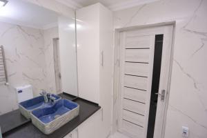 a bathroom with a blue sink and a mirror at Newly Renovated Modern 2 Bed Apt Near Gur-e-Amir -Brown Door in Samarkand