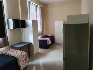 a room with two beds and a flat screen tv at Oasis Residence in Durban