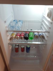 um frigorífico cheio de garrafas e latas em Departamento centrico Alvear em Paraná