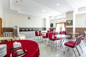 un restaurante con mesas y sillas rojas en una habitación en RedDoorz Plus near Alun Alun Karanganyar, en Karanganyar
