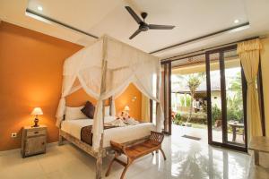 a bedroom with a bed with a canopy at Pondok Kutuh Guest House in Ubud