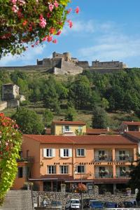 a building in front of a castle on a hill at Logis Hotel Restaurant Le Bellevue in Prats-de-Mollo-la-Preste