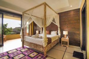 a bedroom with a bed with a canopy at Pondok Kutuh Guest House in Ubud