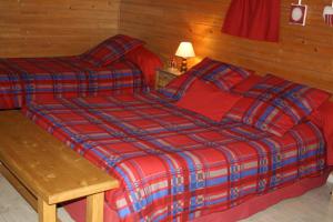 a bedroom with two beds and a wooden wall at Le Clos Pré in La Voivre