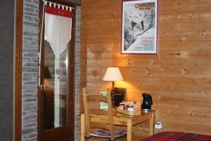 een kamer met een houten muur met een tafel en een lamp bij Le Clos Pré in La Voivre