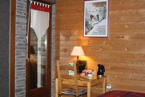 a room with a wooden wall with a table and a lamp at Le Clos Pré in La Voivre