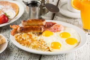 um prato de comida de pequeno-almoço com ovos e bacon em Dolliwarie Guesthouse em Panorama