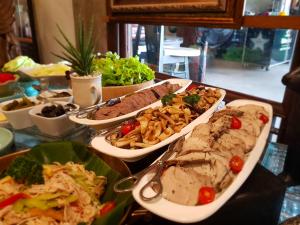 a table with many different dishes of food on it at Ammata Lanta Resort in Lat Krabang