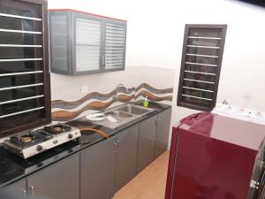 a kitchen with a sink and a stove at Coral Homes in Cochin