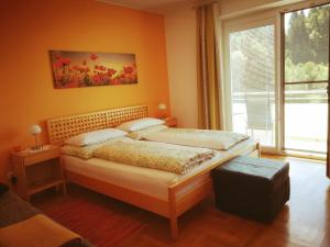 a bedroom with a bed and a large window at Haus Steinfeld in Kirchberg an der Raab