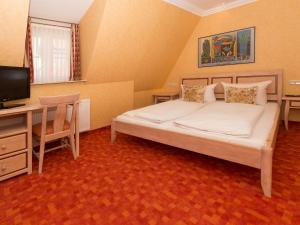 a bedroom with a bed, desk, chair, and lamp at Hotel Kaiserworth Goslar in Goslar