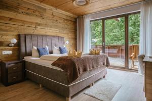a bedroom with a bed with a wooden wall at Hotel Alpennest - Mountain Hideaway in Leutasch in Leutasch