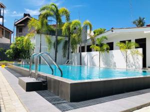 een zwembad voor een gebouw bij Bony's Holiday Inn Negombo in Negombo