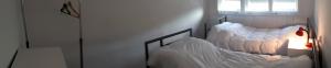 a room with two beds with white sheets at Edelweiss Hostel in Štip