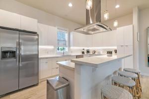a kitchen with white cabinets and a stainless steel refrigerator at New Construction Elegant Villas in New Orleans