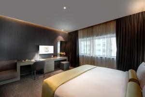 シャルジャにある72 Hotel Sharjahのベッドと机があるホテルの部屋